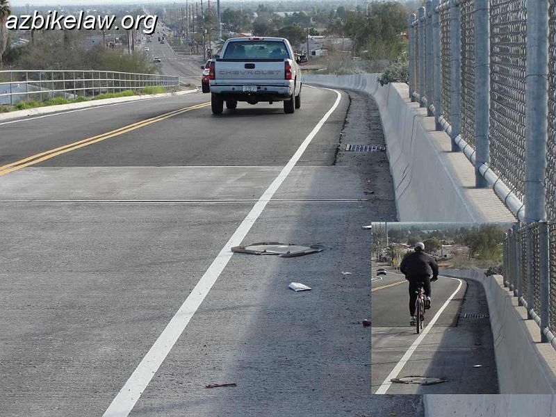GuadalupeBridgeDown.jpg - Guadalupe Bridge, facing east. The asphalt section had been quite broken and was re-done 1/14/2012. This is  the perhaps 600' between the bridge and Calle Sahuaro(i think).  An edge line was placed ~4' from the vertical wall. A drain grate can be seen in the gutter pan. These areas are magnets for debris, and are rarely swept. A ghost of an old edge line is still visible at ~3' -- this line was either intentionally (if so, hooray!) removed once upon a time years ago, or was simply worn away over time. The inset shows a cyclist hugging the line. This section is posted 25mph.