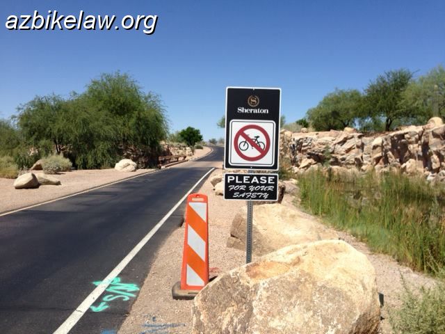 SheratonGricNoBikeSign.jpg - weird, new sign at entrance to Sheraton Wild Horse Pass Resort (not to be confused with the casino). It has an image of an R5-6 reproduced on a larger sign with a black background that says Sheraton, and their logo. Most annoyingly, there is a placard below on a black background that says "PLEASE for your safety". The resort is about a mile beyond this sign